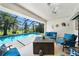 Inviting screened-in patio with cozy seating, a fire pit, and a view of the sparkling pool and tropical greenery at 3724 Bordeaux Dr, Punta Gorda, FL 33950