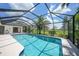 Sparkling screened-in pool with clear blue water, surrounded by lush landscaping, perfect for relaxation and recreation at 3724 Bordeaux Dr, Punta Gorda, FL 33950
