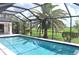 Beautifully screened-in pool area with a view of the green golf course at 3724 Bordeaux Dr, Punta Gorda, FL 33950