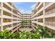 Lush courtyard view with balconies adorned with colorful flower boxes, set against a blue sky at 3730 Cadbury Cir # 616, Venice, FL 34293
