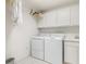 Bright laundry room with modern washer and dryer, and ample storage with white cabinets at 3730 Cadbury Cir # 616, Venice, FL 34293