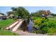A picturesque view of the canal featuring a large brick-lined dock and verdant landscaping at 405 Ridgecrest Dr, Punta Gorda, FL 33982