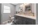 Well-lit bathroom with a double vanity, two mirrors, and gray wood-look floors at 405 Ridgecrest Dr, Punta Gorda, FL 33982