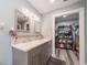 Bathroom features a double vanity, two mirrors and a view into a walk-in closet/storage area at 405 Ridgecrest Dr, Punta Gorda, FL 33982