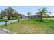 Charming home featuring mature palm trees, a long driveway, and lush green lawn at 405 Ridgecrest Dr, Punta Gorda, FL 33982