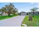 Charming home featuring mature trees, a long driveway, and lush green lawn at 405 Ridgecrest Dr, Punta Gorda, FL 33982