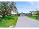 Well-manicured home featuring mature trees, a long driveway, and lush green lawn at 405 Ridgecrest Dr, Punta Gorda, FL 33982