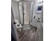 Compact bathroom with a modern glass shower enclosure, white vanity, and wood flooring at 4158 Tamiami Trl # U4, Port Charlotte, FL 33952