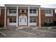 Classic brick building with white columns and well-maintained landscaping offers a welcoming entrance at 4158 Tamiami Trl # U4, Port Charlotte, FL 33952