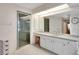 Light and airy bathroom featuring a large mirror, glass shower door, and neutral color palette at 421 Strasburg Dr, Port Charlotte, FL 33954