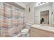 Bathroom with a colorful shower curtain, toilet, and mirror over the vanity at 421 Strasburg Dr, Port Charlotte, FL 33954