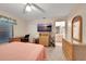 Bedroom with pink comforter, desk, TV and a view into the bathroom at 421 Strasburg Dr, Port Charlotte, FL 33954