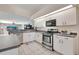 Clean kitchen with stainless steel appliances, white cabinets, and ample counter space at 421 Strasburg Dr, Port Charlotte, FL 33954