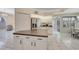 White kitchen features tiled floors, stainless steel appliances, breakfast nook, and center island at 421 Strasburg Dr, Port Charlotte, FL 33954
