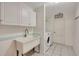Clean laundry room with white cabinets, utility sink and modern washer/dryer at 421 Strasburg Dr, Port Charlotte, FL 33954