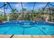 Screened-in pool with cascading water feature, lush greenery, and decorative accents at 421 Strasburg Dr, Port Charlotte, FL 33954