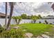 Well-maintained backyard featuring green lawn, mature trees, and partial privacy fence at 4268 Leesburg Ave, North Port, FL 34288