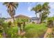 Landscaped backyard with manicured lawn, tropical foliage, and screened pool enclosure at 4268 Leesburg Ave, North Port, FL 34288