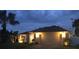 Exterior home view at night featuring landscaping and a two car garage at 4268 Leesburg Ave, North Port, FL 34288
