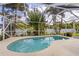 Beautiful pool surrounded by lush tropical landscaping and a screened enclosure at 4268 Leesburg Ave, North Port, FL 34288