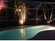 A sparkling swimming pool at night surrounded by lush tropical landscaping at 4268 Leesburg Ave, North Port, FL 34288