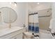 Bright bathroom with a shower and tub combo, a round mirror, and modern finishes at 42771 Valley Brooks St, Punta Gorda, FL 33982