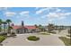 A well-manicured lawn leads up to the clubhouse exterior with red roof and stone columns at 42771 Valley Brooks St, Punta Gorda, FL 33982
