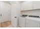 Well-lit laundry room with a washer, dryer, and white cabinets for ample storage at 42771 Valley Brooks St, Punta Gorda, FL 33982