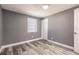 A simple bedroom design with minimalist decor that features wood-look flooring and neutral gray walls at 4371 Guard St, Punta Gorda, FL 33980