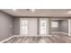 An open living room features grey walls, wood-look flooring, and double doors at 4371 Guard St, Punta Gorda, FL 33980