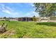 Large backyard with a screened-in lanai, mature trees, and ample green space at 4509 Wynkoop Cir, Port Charlotte, FL 33948