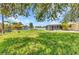 Expansive backyard featuring lush green grass, mature trees, and a screened-in lanai at 4509 Wynkoop Cir, Port Charlotte, FL 33948