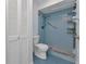 Bathroom featuring blue tile, walk-in shower, toilet, and storage unit at 4509 Wynkoop Cir, Port Charlotte, FL 33948