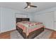 Cozy bedroom features wood floors, ceiling fan, and double-door closet at 4509 Wynkoop Cir, Port Charlotte, FL 33948