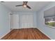 Bedroom with hardwood floors, ceiling fan and a closet with white louvered doors at 4509 Wynkoop Cir, Port Charlotte, FL 33948