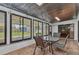 Enclosed patio with tile flooring, large windows, and a table with seating for four at 4509 Wynkoop Cir, Port Charlotte, FL 33948