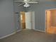 Bedroom featuring neutral carpet, paint, standard ceiling fan, and access to en-suite bathroom and walk-in closet at 500 Winwood Ct, Port Charlotte, FL 33954