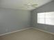Bright bedroom with neutral carpet, paint, ample natural light streaming through the window, and ceiling fan at 500 Winwood Ct, Port Charlotte, FL 33954