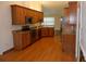Well-equipped kitchen with wood cabinets, granite counters, modern appliances, and wood flooring adjacent to dining area at 500 Winwood Ct, Port Charlotte, FL 33954