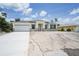 Charming single-story home with a light exterior, attached garage and freshly poured concrete driveway at 5018 Cillette Ave, North Port, FL 34288