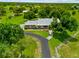 Gorgeous aerial view of the home, featuring a well-manicured lawn, mature trees, and a curving driveway at 5221 Blackjack Cir, Punta Gorda, FL 33982