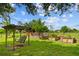 Backyard featuring a swing set, raised garden beds, and barn, ideal for gardening and outdoor enjoyment at 5221 Blackjack Cir, Punta Gorda, FL 33982