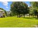 Lush backyard with mature trees, perfect for outdoor activities and relaxation, with a view of the barn at 5221 Blackjack Cir, Punta Gorda, FL 33982