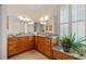 Bright bathroom featuring granite countertops, wood cabinets, and a large mirror at 5221 Blackjack Cir, Punta Gorda, FL 33982