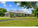 Spacious ranch-style home with a metal roof, green shutters, and lush landscaping at 5221 Blackjack Cir, Punta Gorda, FL 33982