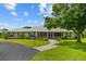Well-maintained home featuring a metal roof, screened porch, and attractive landscaping at 5221 Blackjack Cir, Punta Gorda, FL 33982