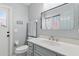 Bathroom featuring modern vanity, toilet, and mirror; decorated in relaxing light grey tones at 5273 Crestline Ter, Port Charlotte, FL 33981