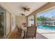 Covered outdoor dining area with ceiling fans, opening to a screened pool and lush landscaping at 5273 Crestline Ter, Port Charlotte, FL 33981