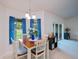 Cozy dining room with square wood table, white chairs, and bright blue curtains allowing natural light to flow through at 591 San Ambrosio St, Punta Gorda, FL 33983
