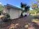 View of exterior stucco home showing palm tree and AC unit at 726 Chevy Chase St, Port Charlotte, FL 33948